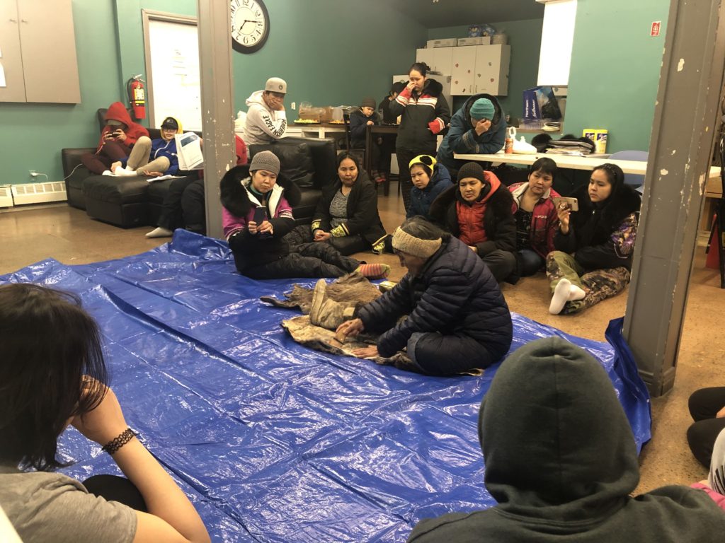 Elder Mary Anowtalik from Arviat shows community members how to scrape a caribou hide. (credit: Michelle Ewacha, CPAWS Manitoba)