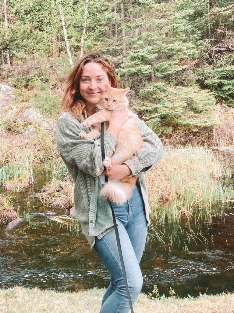 Riley Chervinski holding her cat while on a hike.