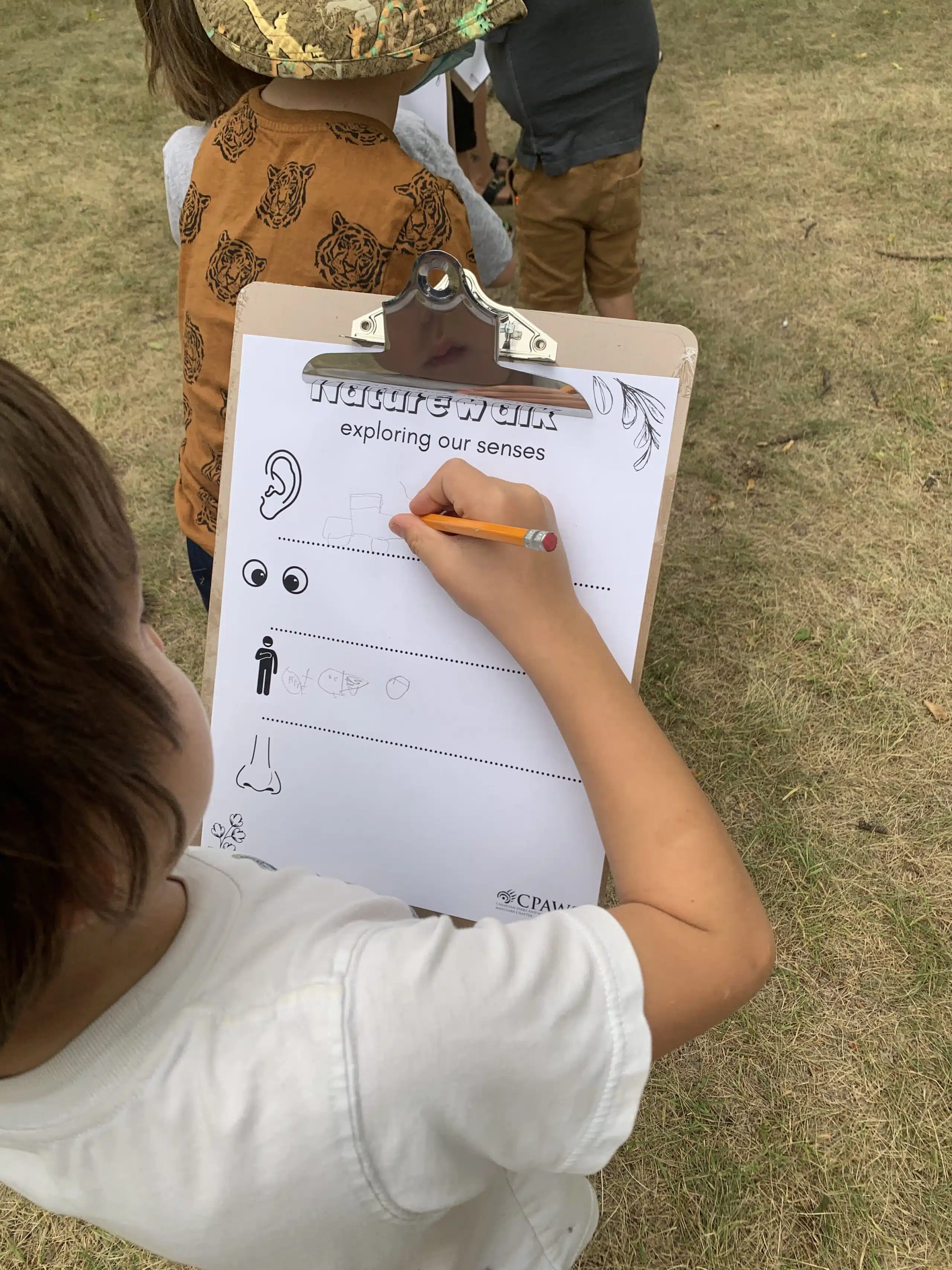 child takes notes during nature walk