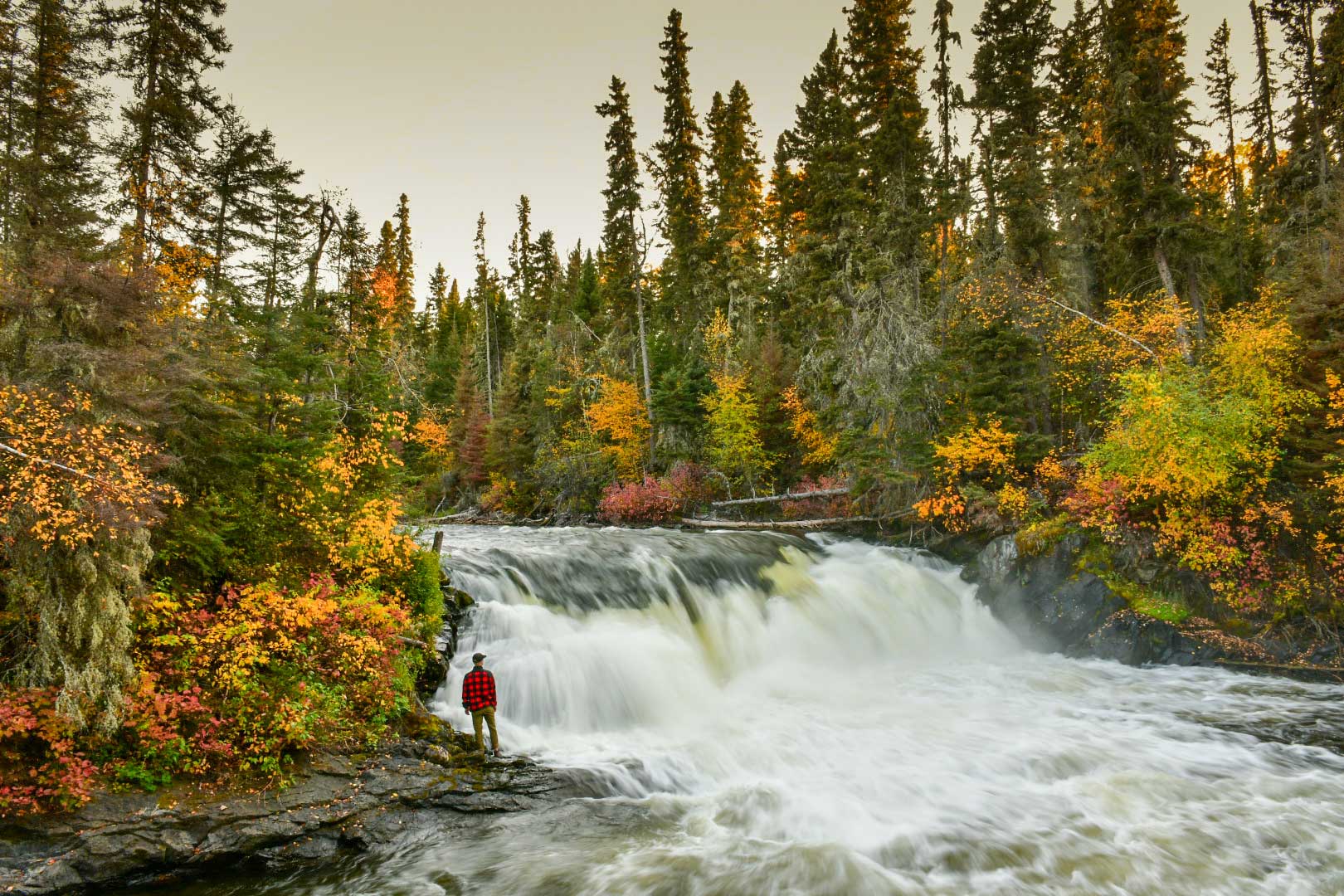 A person stands near Wekusko Falls in Manitoba.