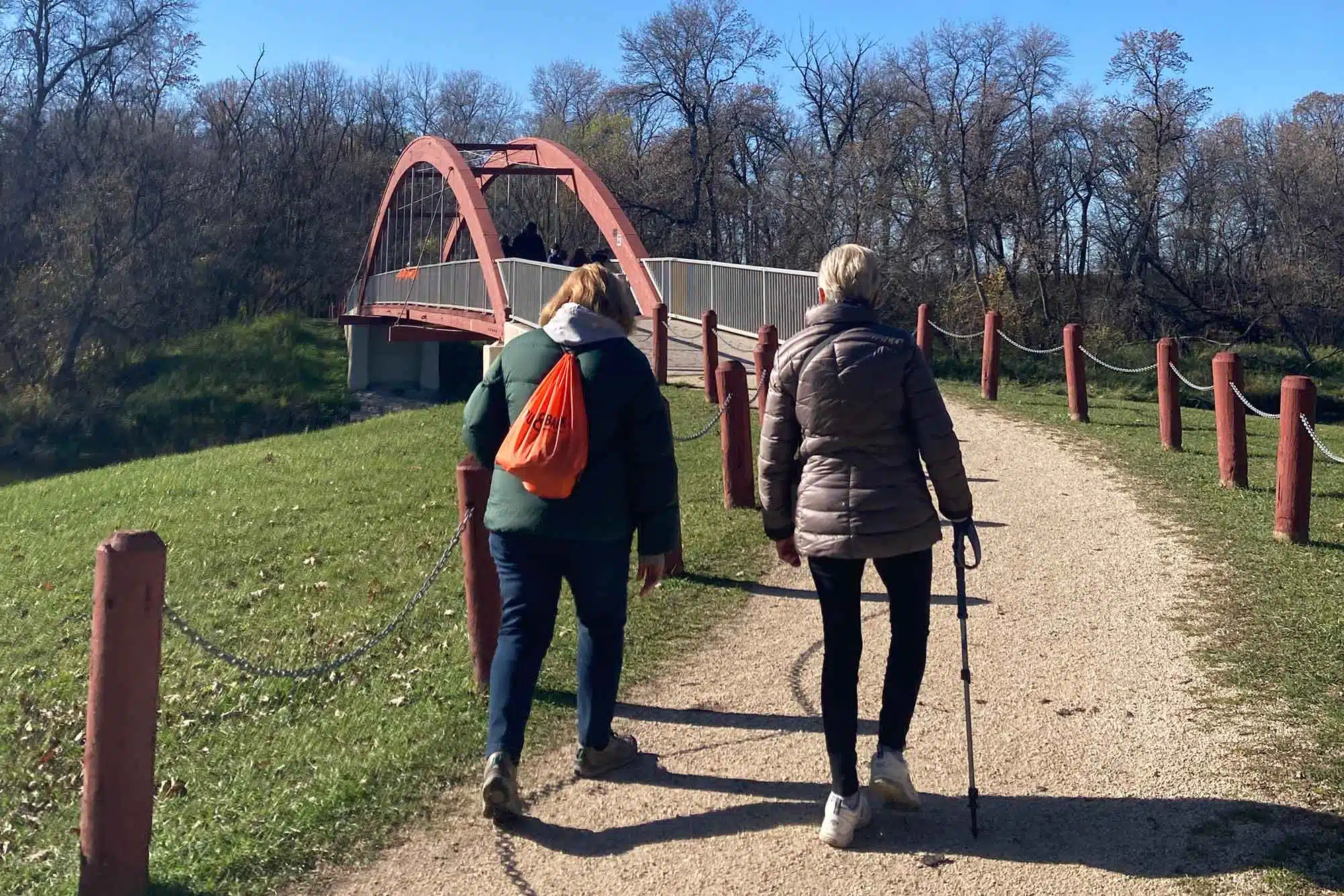 Two people approaching the bridge while hiking the La Barrière Park Loop.