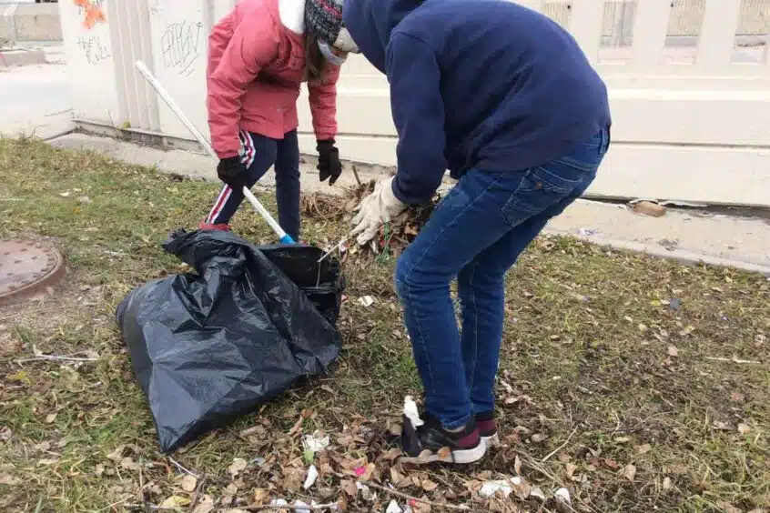 Two students pick up litter for the CPAWS Manitoba Student Litter Cleanup Challenge.