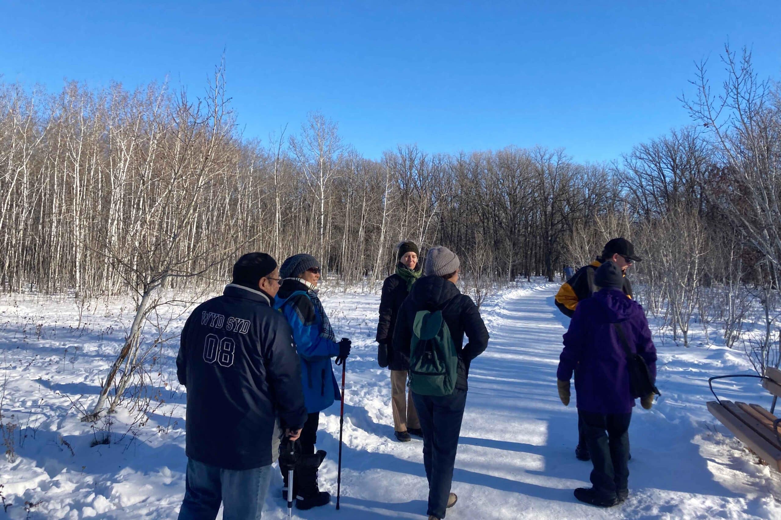 A group of people hike on a trail at Bois-des-Esprits in Winnipeg.