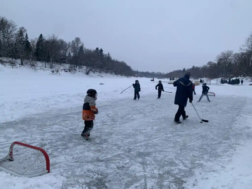 Kids playing hockey on river rink Winnipeg 2021 credit Mira Oberman