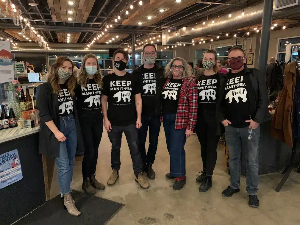 7 CPAWS Manitoba staff members stand in a line wearing masks wearing CPAWS t-shirts