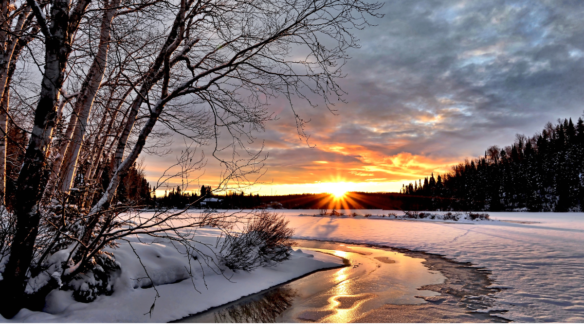 sunset over a partially frozen river in winter