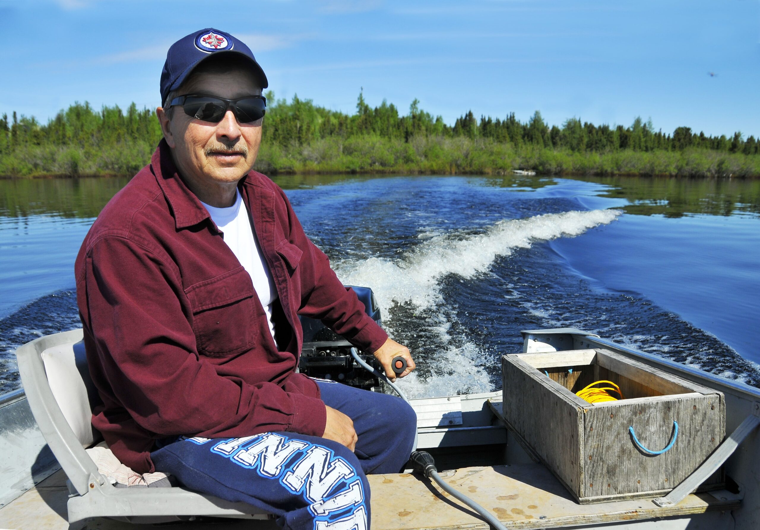 Ernie Bussidor steers a boat across Tadoule Lake in June 2018. Credit Ron Thiessen