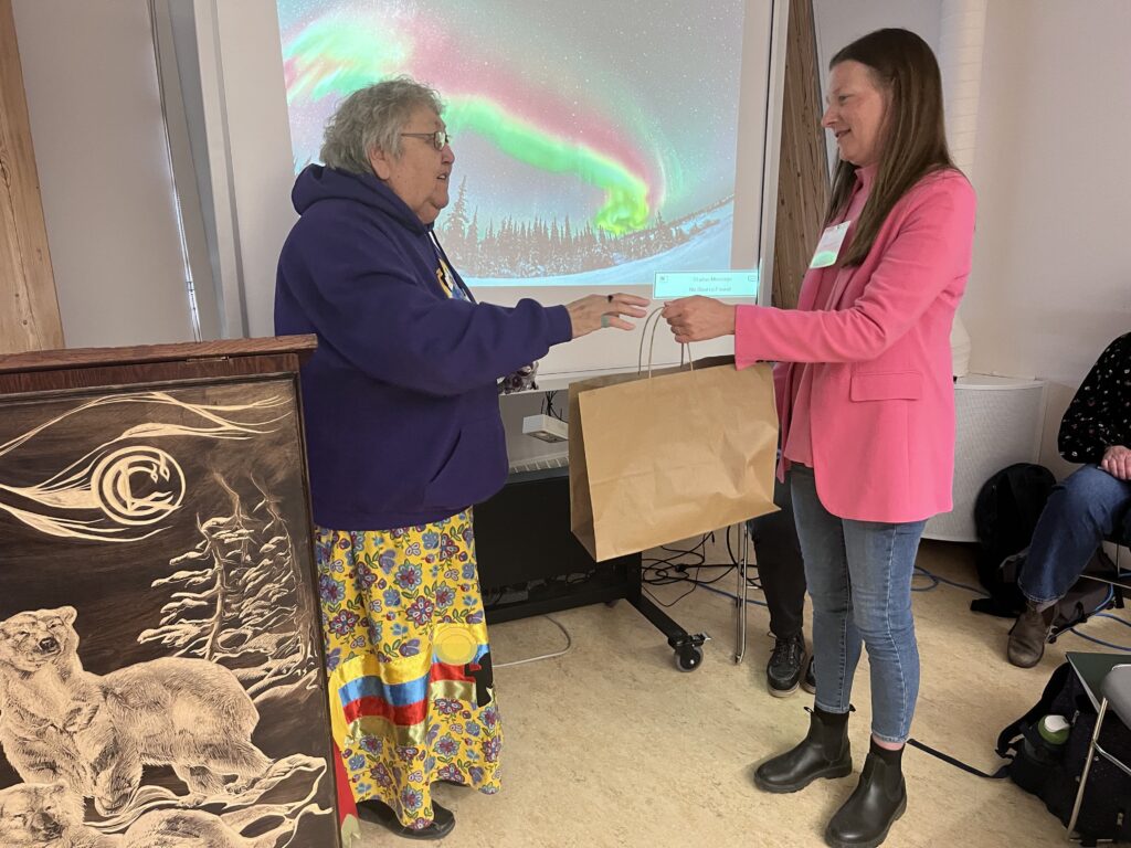 Elder Flora Beardy of York Factory First Nation presents Environment and Climate Change Minister Tracy Schmidt with a gift at the Honouring the Water gathering in Churchill. Credit Mira Oberman, CPAWS Manitoba